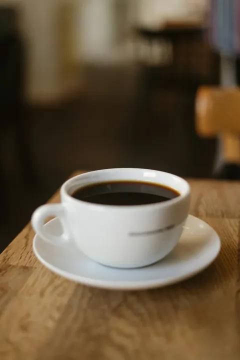 Coffee in a white cup, used in an illustrative café website concept